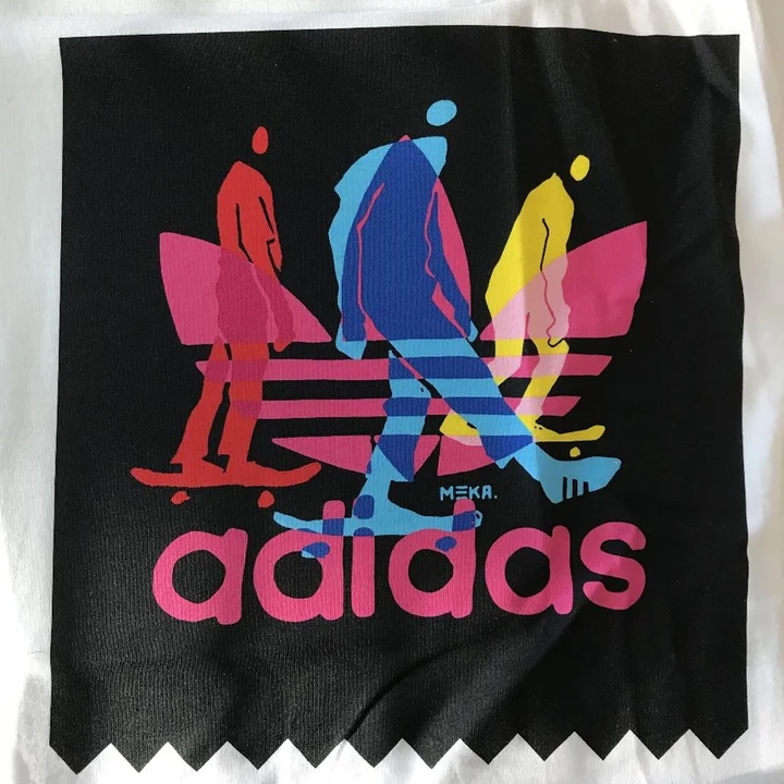 Black tee — three trefoil characters on boards, full colour