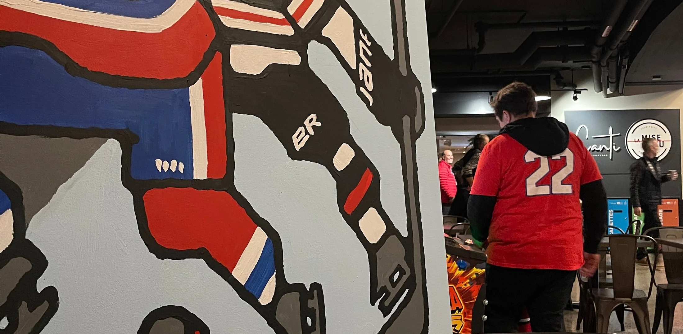 The mural in place at the Bell Centre, a fan walking past in a number 22 jersey