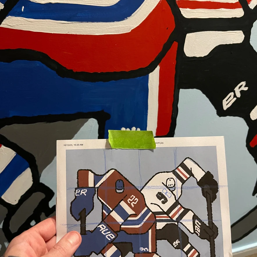 The painted panel next to the reference sketch held up in front of it