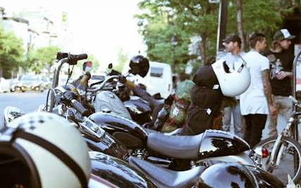 Bikes lined up in the street, the crew hanging around them