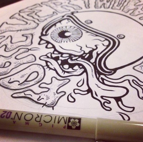 Micron pen drawing — eye and skull inked in the sketchbook