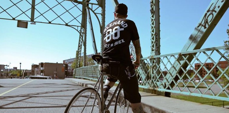 Rider on a fixed gear crossing the bridge in an Idlehand tee