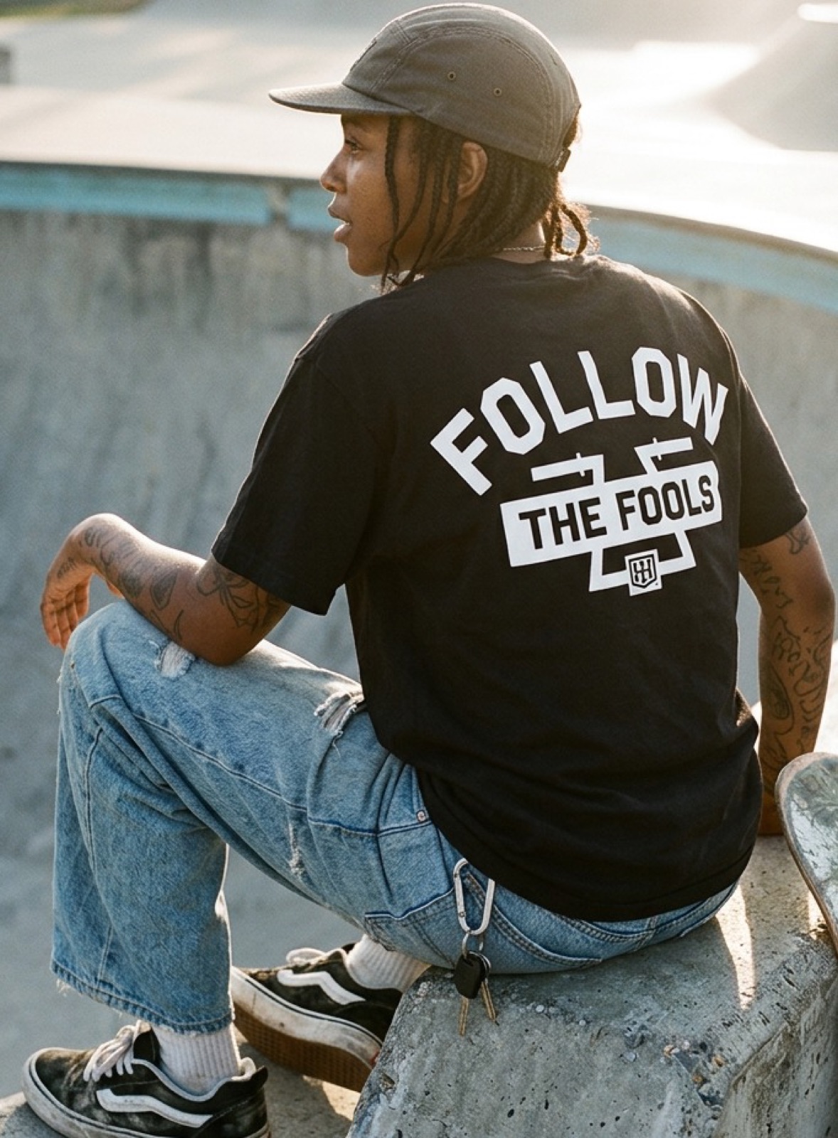 Skater sitting on the coping in a Follow the Fools tee