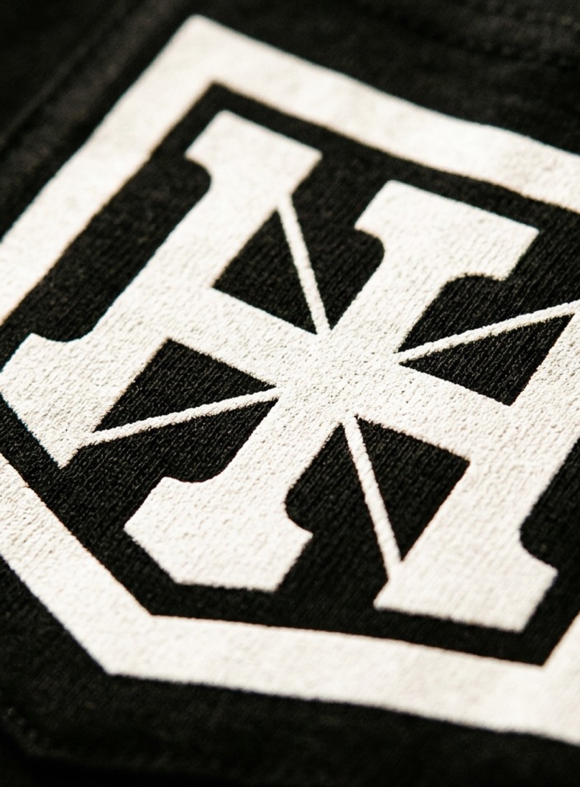 Idlehand crest printed on black cotton, close up on the weave