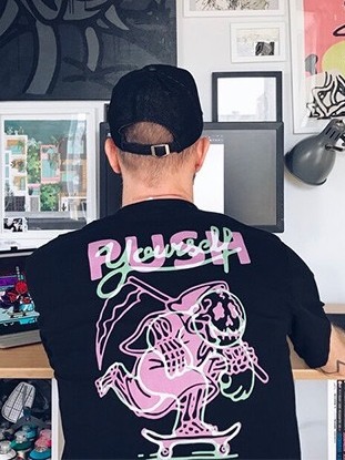 At the desk in the studio, artwork on the walls