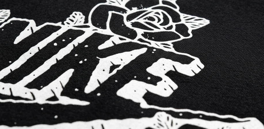 NIKE lettering and roses screen-printed on black, close up on the fabric
