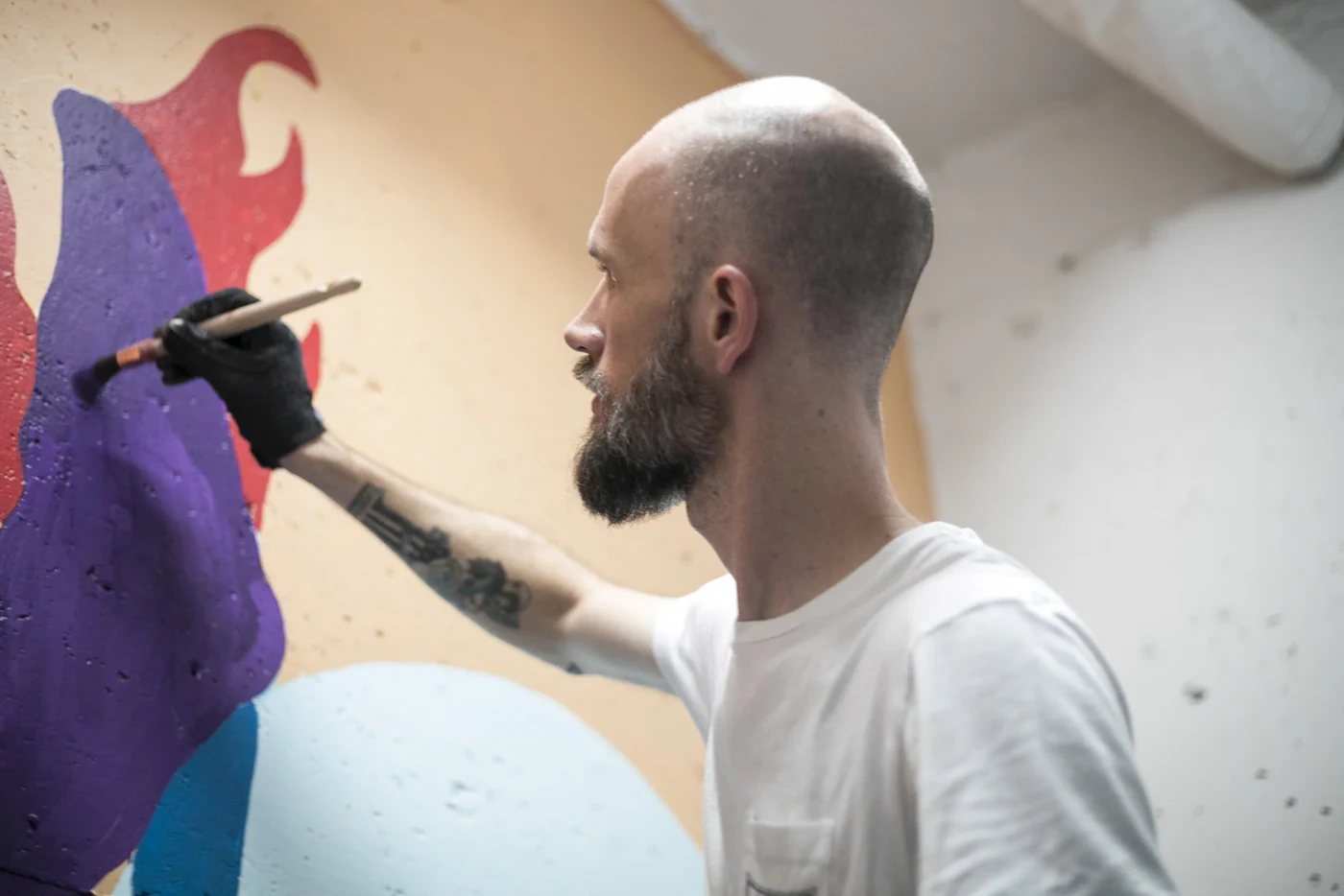 Painting the Keep Pushing mural brush by brush in the Romeo's Museum stairwell, 2018