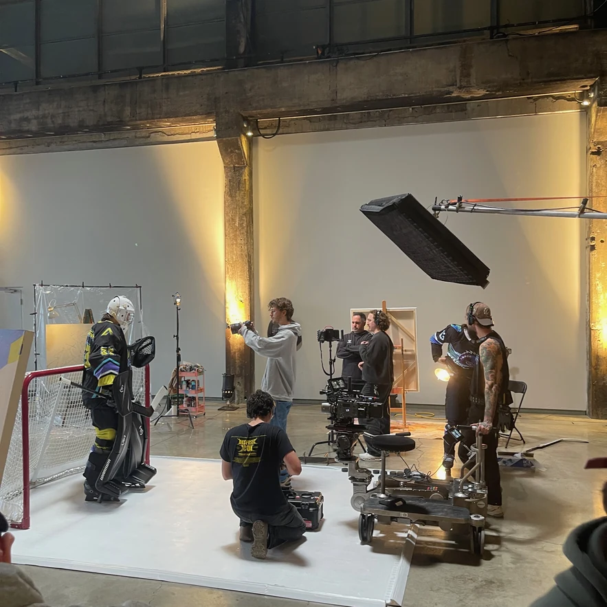 The lit set at Fonderie Darling: goalie in the crease, camera and crew around the white floor