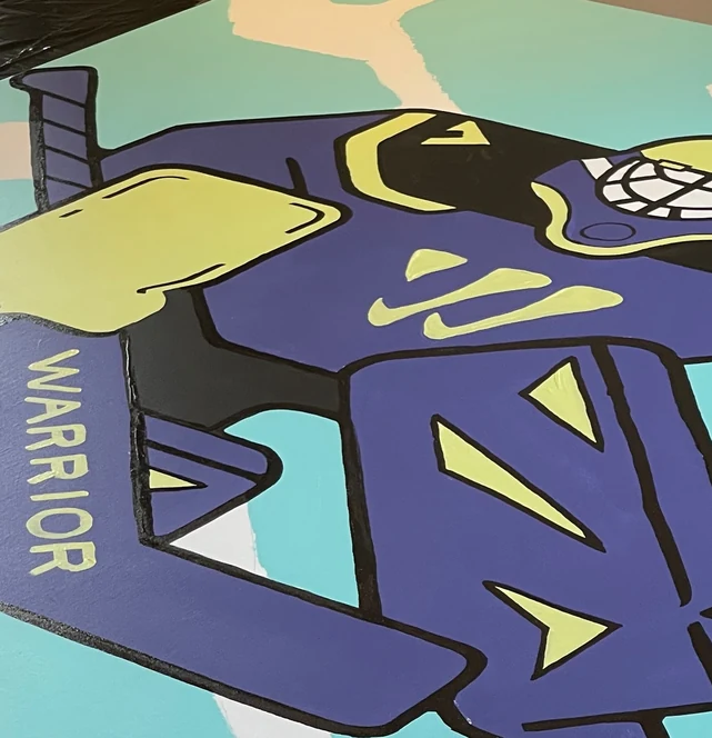 Close-up on the painted pads: flat purple, yellow chevrons, the Warrior wordmark