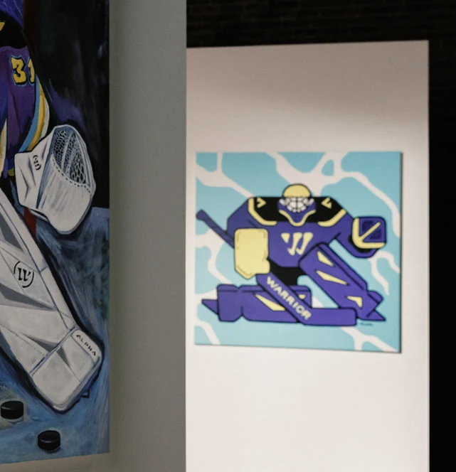 The piece hung on the set wall next to the goalie stick