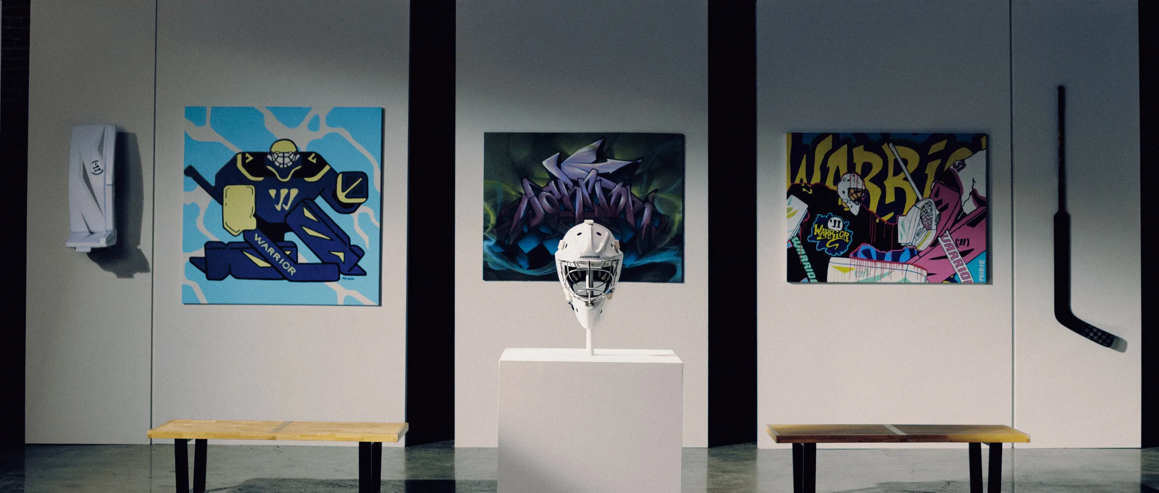 The five finished pieces hung on the gallery wall of the set, sculpted mask on a plinth at the centre